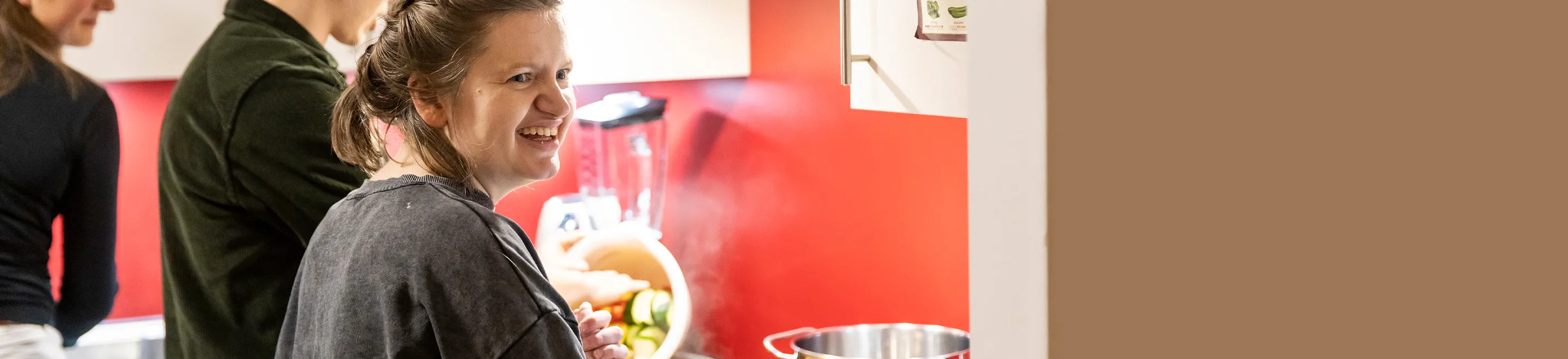 Eine junge Frau beim Kochen in der Küche einer Wohngemeinschaft.