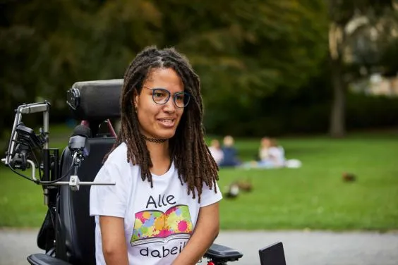 Eine junge Frau in einem E-Rollstuhl.
