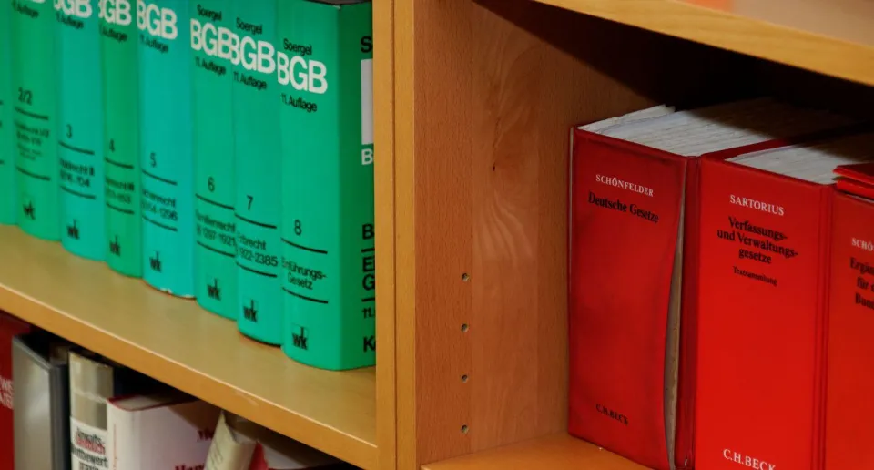 Ein Bücherregal mit Gesetzbüchern und Literatur zu Gesetzen.