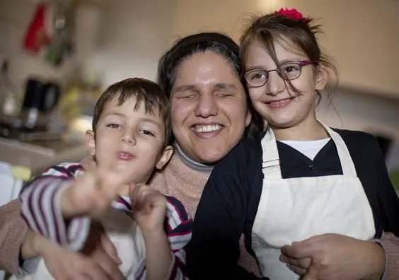 Eine Mutter mit ihrem Sohn und ihrer Tochter auf dem Schoß.