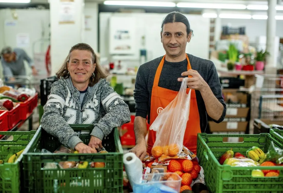 Ein Mann und eine Frau packen Lebensmittel ab.