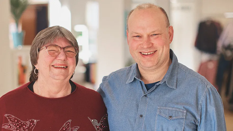 Ein Mann und eine Frau stehen lachend nebeneinander