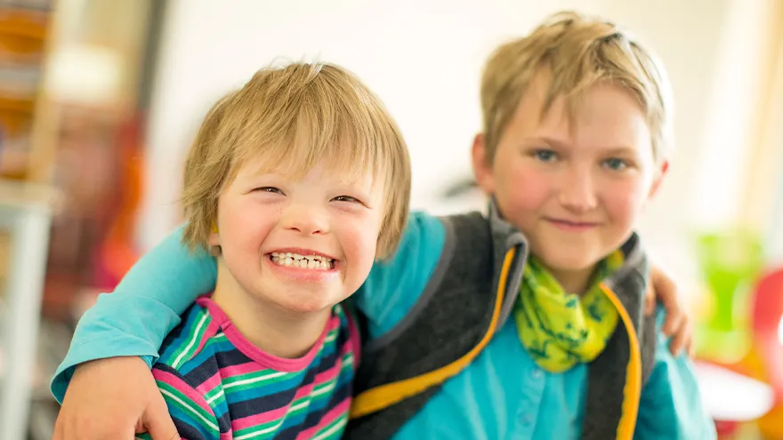 Ein Junge mit Downsyndrom und ein Junge ohne Behinderung