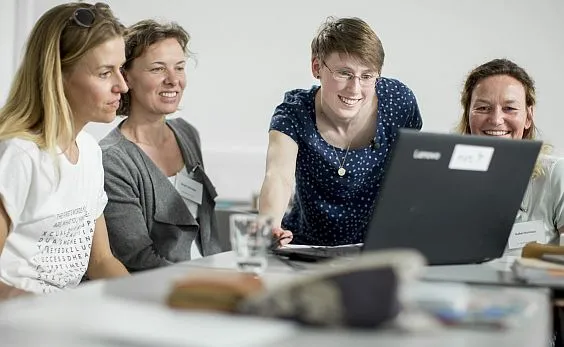 Mehrere Frauen schauen auf den Bildschirm eines Computers.