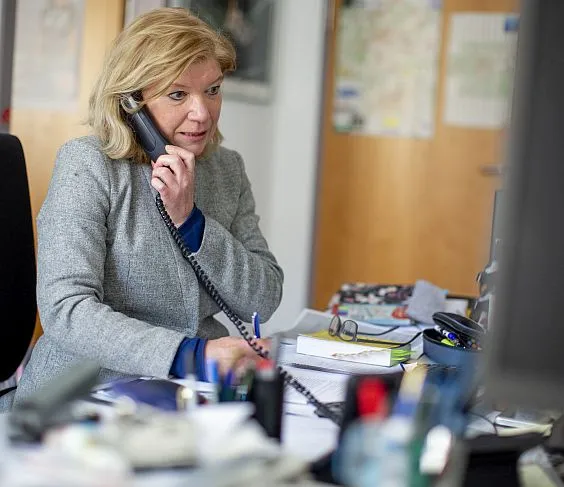 Eine Frau telefoniert und schaut auf den Computerbildschirm.