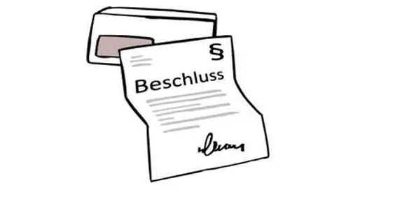 Ein Briefumschlag und ein Brief, auf dem "Beschluss" steht.