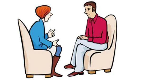 Ein Mann und eine Frau sitzen sich gegenüber und sprechen miteinander.