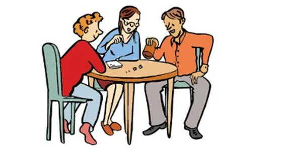 Zwei Frauen und ein Mann sitzen an einem Tisch und spielen ein Würfelspiel miteinander.