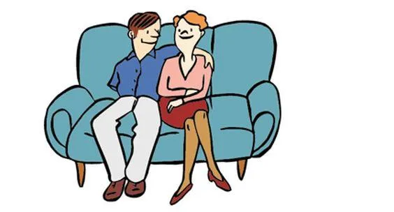 Eine Frau hilft einer anderen Frau am Computer. Eine andere Frau steht neben einem Sofa, auf dem ein Mann und eine Frau sitzen.