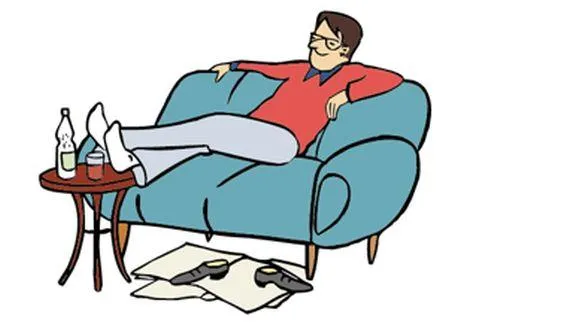 Ein Mann sitzt auf einem Sofa und hat die Füße auf einen Tisch gelegt.