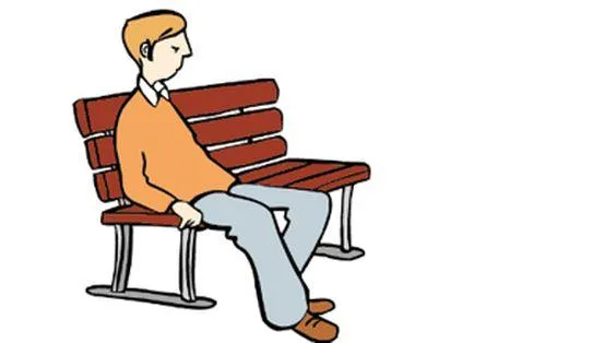 Ein Mann sitzt alleine auf einer Parkbank.
