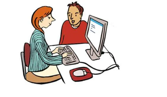 Ein Mann spricht mit einer Frau, die an einem Computer sitzt.