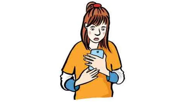 Ein Mädchen guckt erschrocken auf sein Handy.