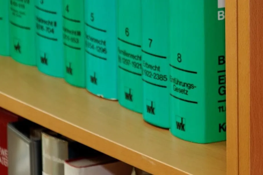 Ein Bücherregal mit Gesetzbüchern und Literatur zu Gesetzen.