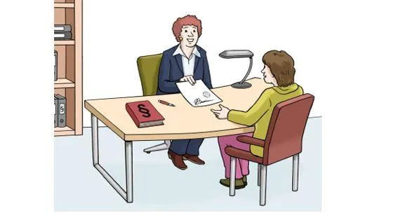 Zwei Frauen sitzen in einem Büro am Schreibtisch. Die eine Frau überreicht der anderen ein Dokument.