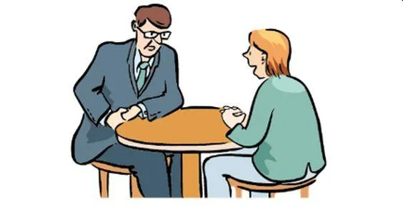 Ein Mann und eine Frau sitzen an einem Tisch und sprechen miteinander.