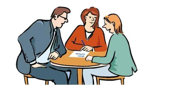 Ein Mann und zwei Frauen sitzen an einem Tisch und reden miteinander.