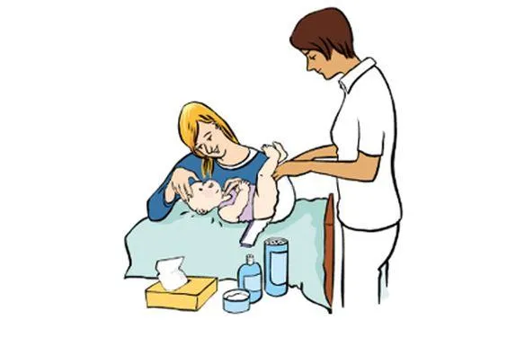 Eine sitzende Frau streichelt ein Baby, während eine stehende Frau in weißer Kleidung das Baby wickelt.