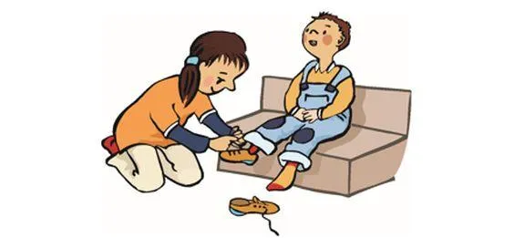 Ein Mädchen bindet einem kleinen Jungen die Schuhe zu.